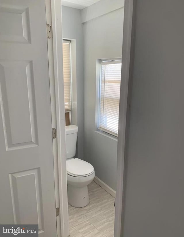 bathroom featuring wood-type flooring and toilet