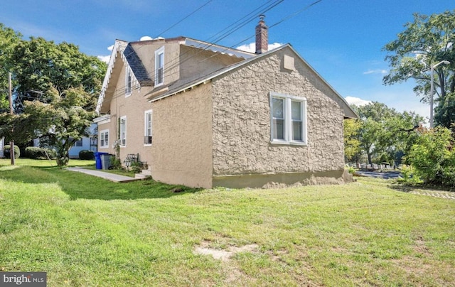 view of side of home featuring a lawn