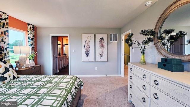 bedroom with light carpet and ensuite bathroom