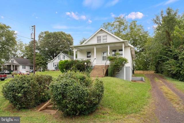 bungalow-style home with a front yard and covered porch