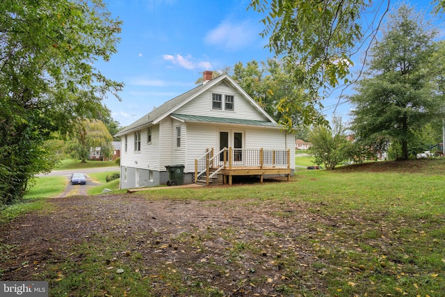 back of property with a wooden deck and a lawn