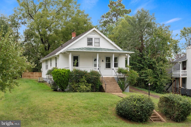 view of front of property featuring covered porch, central AC, and a front lawn