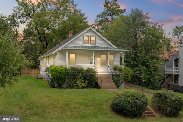 view of front of property with a lawn and a porch