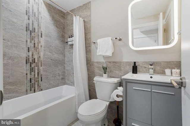 full bathroom featuring vanity, tile walls, shower / tub combo, and toilet