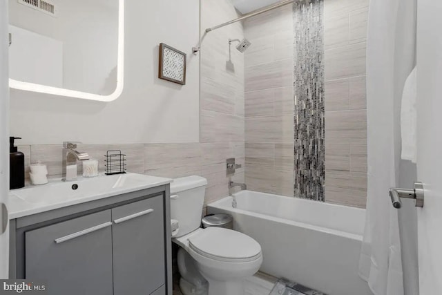 full bathroom featuring tile walls, shower / tub combo, vanity, and toilet