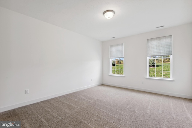 carpeted empty room with baseboards and visible vents
