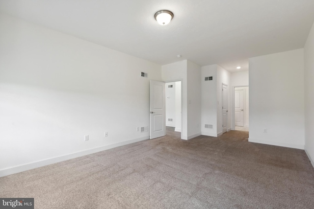 spare room with baseboards, visible vents, and carpet floors