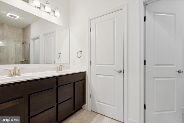 bathroom featuring a tile shower and vanity