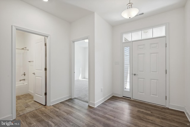 entrance foyer with baseboards, visible vents, and wood finished floors