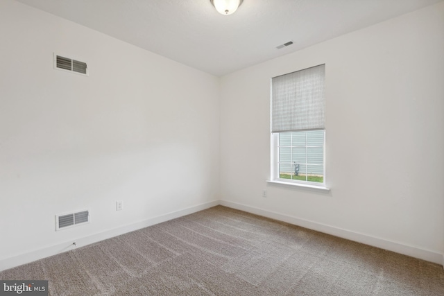 spare room featuring carpet flooring and visible vents