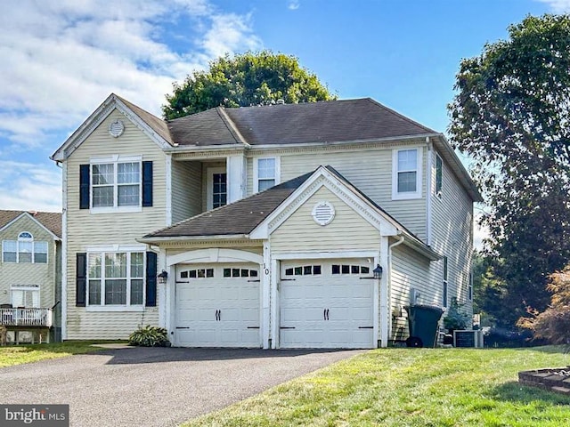 front of property featuring a front yard, a garage, and central air condition unit