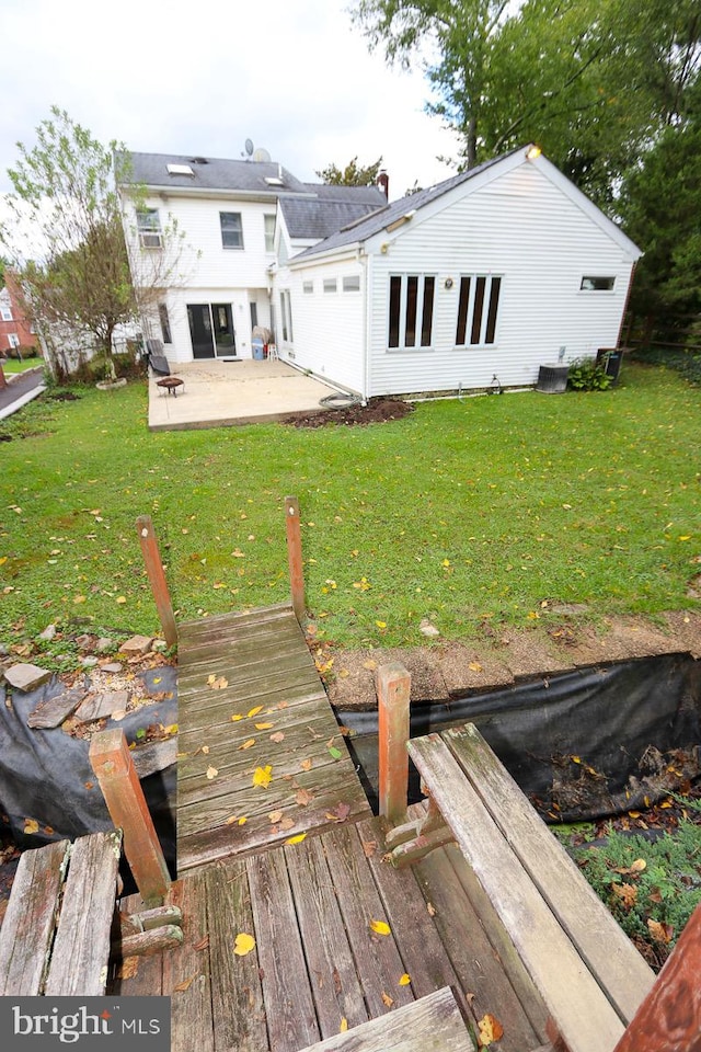 rear view of property with a lawn and a patio