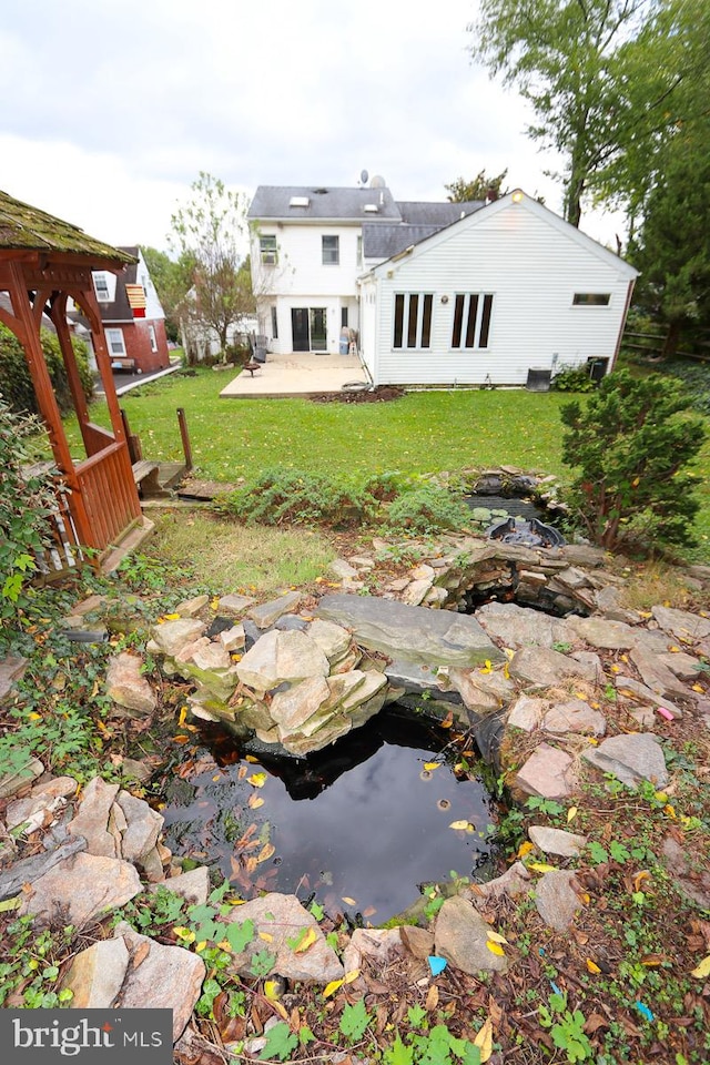 rear view of property with a patio and a yard