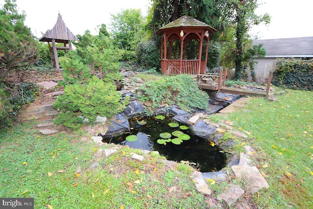 view of yard with a gazebo and a small pond