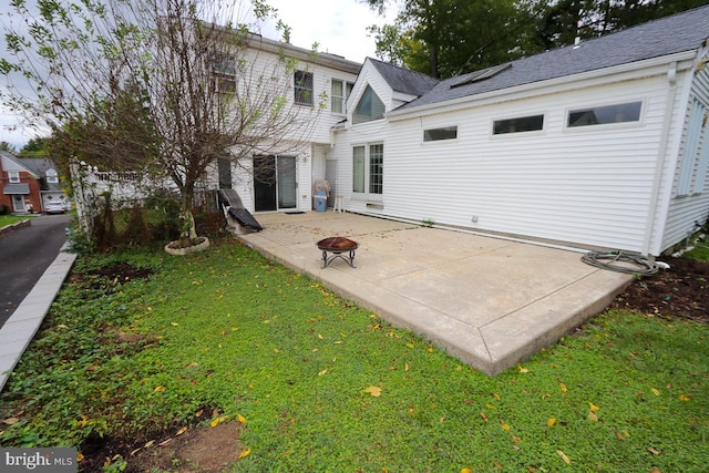 back of property with a lawn and a patio area