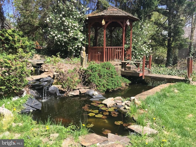 view of yard with a gazebo and a garden pond