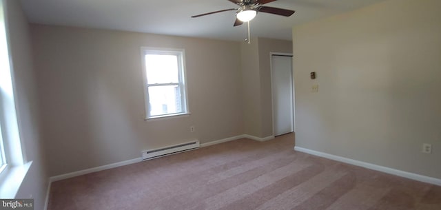 carpeted spare room featuring ceiling fan and baseboard heating