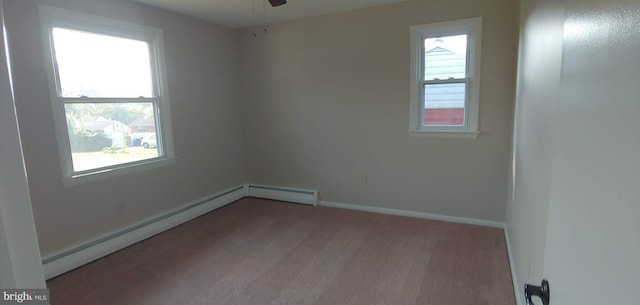 empty room with light hardwood / wood-style flooring, a baseboard heating unit, ceiling fan, and a wealth of natural light