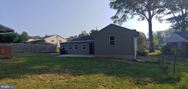 back of house with a lawn and a patio