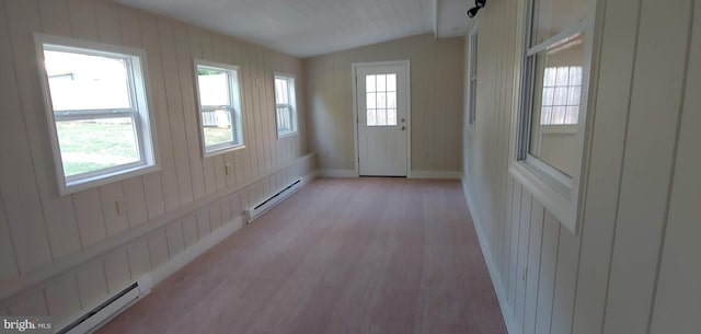 doorway to outside featuring lofted ceiling, wood walls, a baseboard heating unit, and light hardwood / wood-style flooring