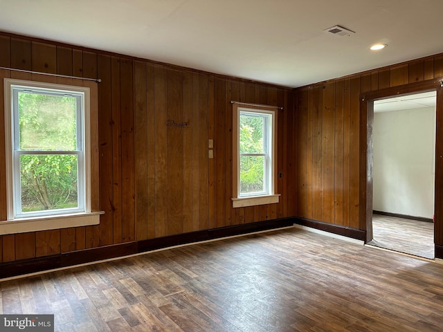 empty room with wood walls and dark hardwood / wood-style floors