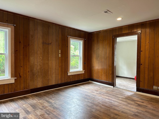 empty room with wooden walls and dark hardwood / wood-style floors