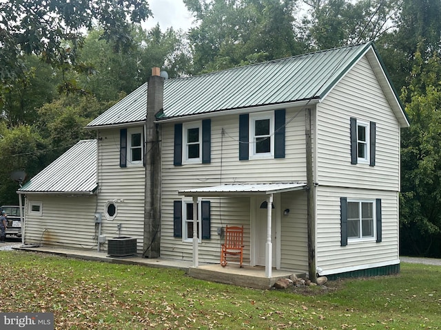 back of property with a patio area, central AC, and a lawn