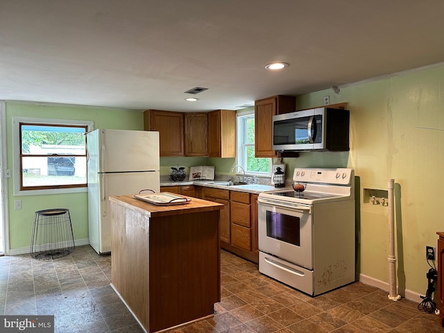 kitchen featuring white appliances, a center island, and sink