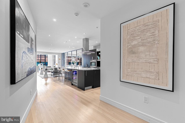 hallway with wine cooler and light hardwood / wood-style flooring