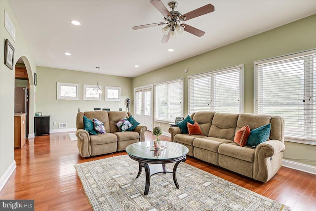 living room with wood-type flooring and ceiling fan