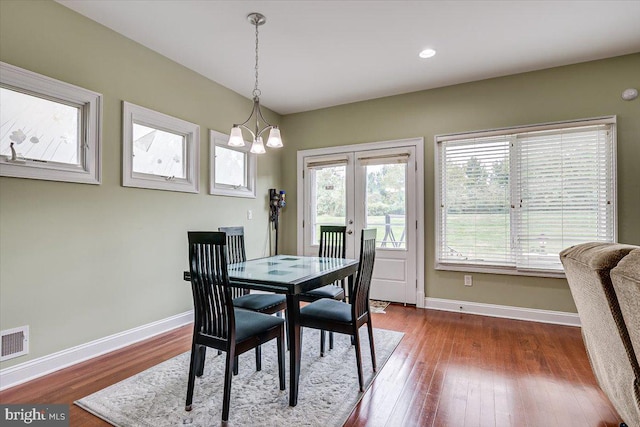 dining area with hardwood / wood-style flooring and a chandelier