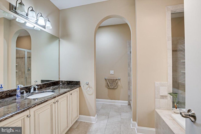 bathroom featuring vanity, plus walk in shower, and tile patterned flooring