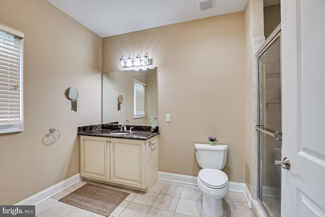 bathroom with tile patterned floors, a shower with shower door, vanity, and toilet