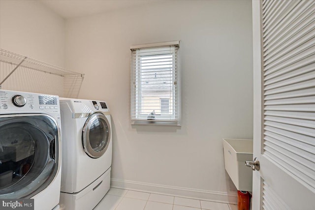 laundry room with washer and clothes dryer and light tile patterned flooring