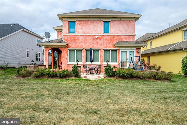 back of property featuring a lawn and a patio area