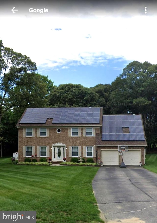 view of property with solar panels, a front yard, and a garage