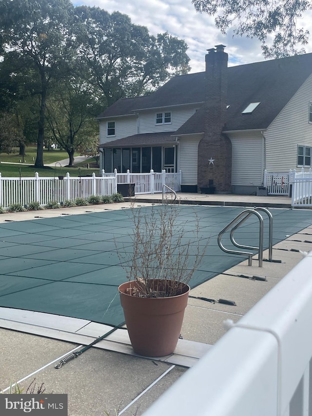 view of pool with a patio and a sunroom