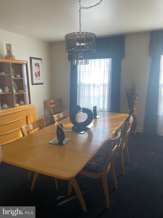 dining space featuring a notable chandelier and carpet