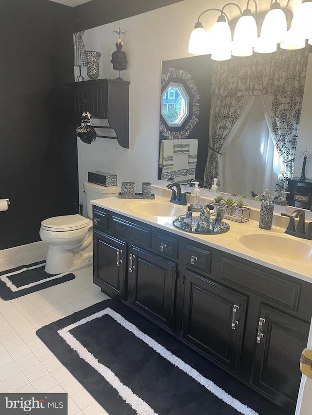 bathroom with toilet, vanity, and tile patterned flooring