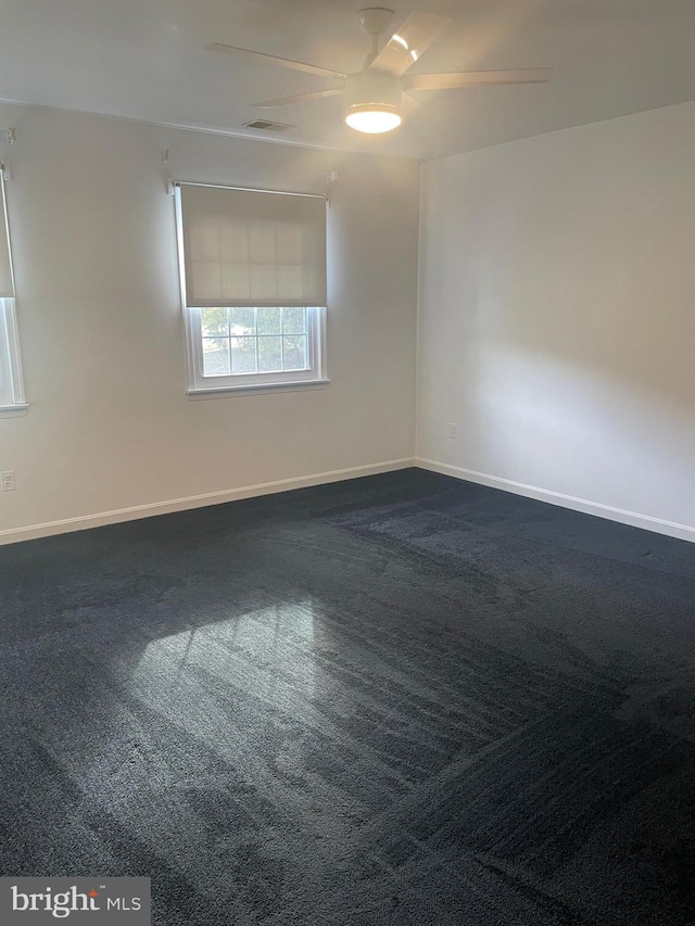 carpeted spare room with ceiling fan