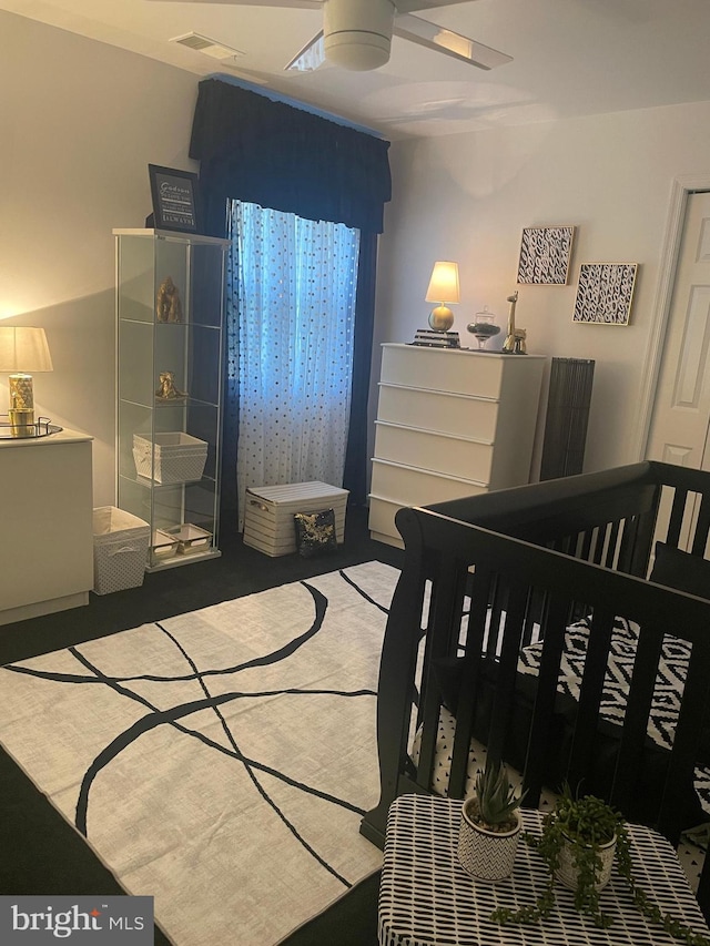 bedroom featuring carpet flooring, a crib, and ceiling fan