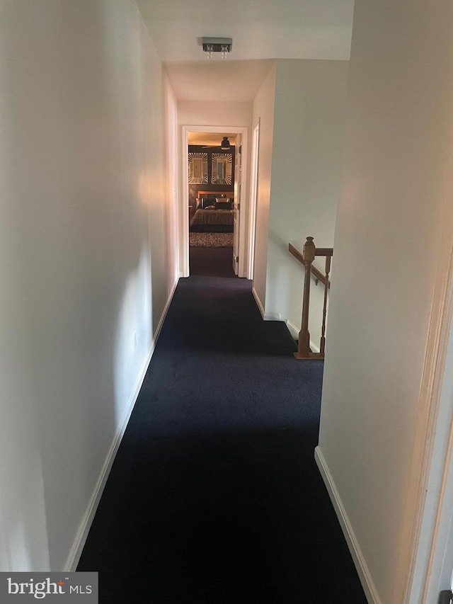 corridor featuring dark carpet