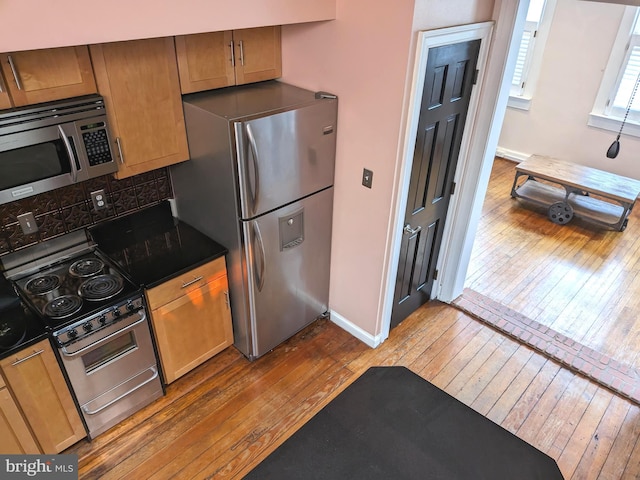 kitchen featuring appliances with stainless steel finishes and hardwood / wood-style floors