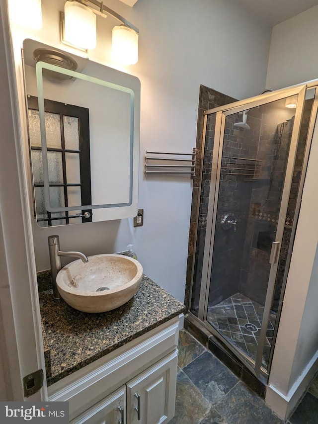 bathroom with walk in shower and vanity