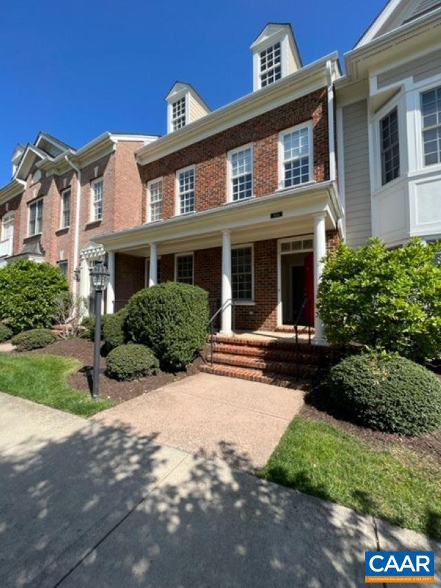 townhome / multi-family property featuring covered porch