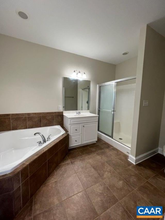 bathroom with plus walk in shower, tile patterned flooring, and vanity