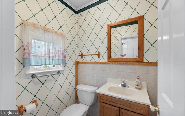 bathroom with ornamental molding, vanity, tile walls, and toilet