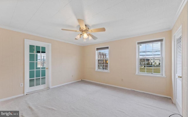 interior space featuring ceiling fan, crown molding, light carpet, and multiple windows