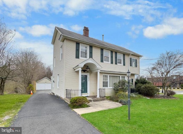 view of front of home featuring an outbuilding, a garage, and a front yard