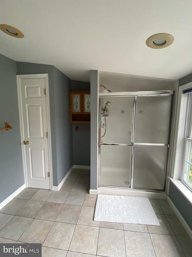 bathroom with lofted ceiling, an enclosed shower, and tile patterned floors